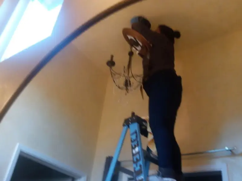 Electrician installing a chandelier in a Norway residence